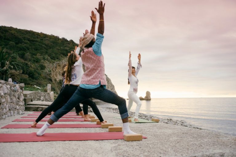 yogis practicing yoga on a beach in Montenegro